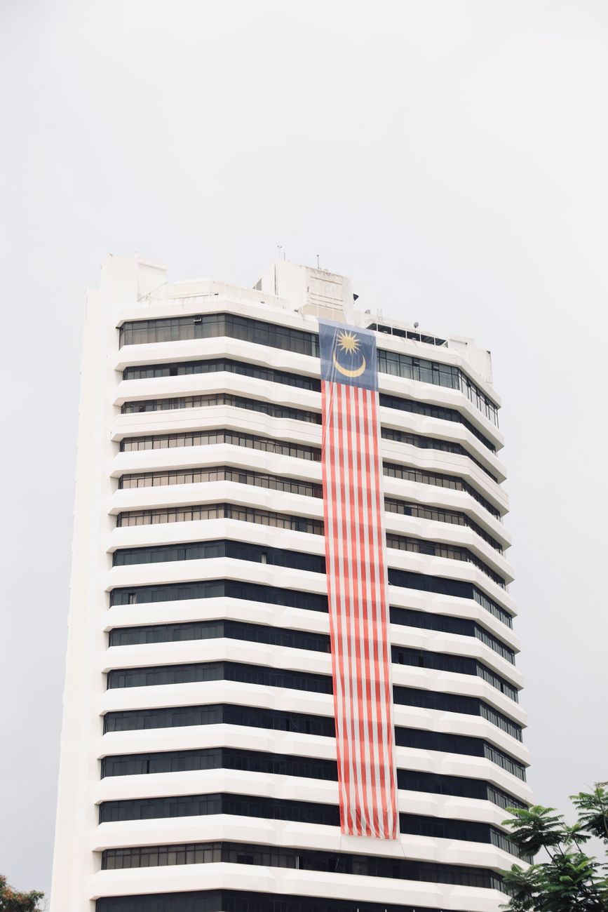 Een modern kantoorgebouw in Kuala Lumpur versierd met een grote Malaysische vlag.