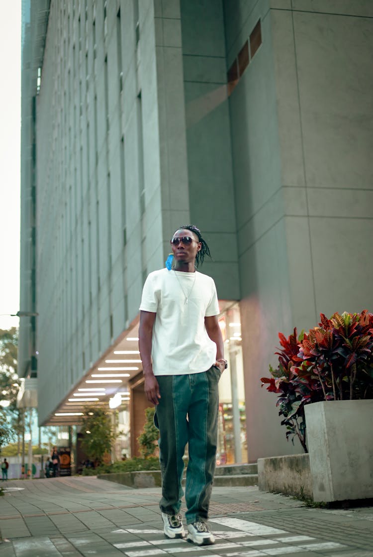 Man In A Casual Outfit Walking On The Sidewalk In City 