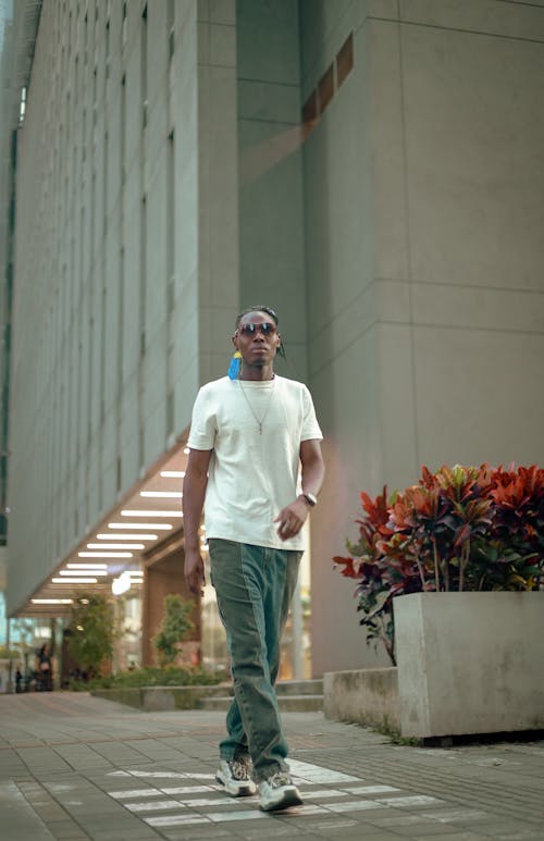 Man in a Casual Outfit Walking on the Sidewalk in City 