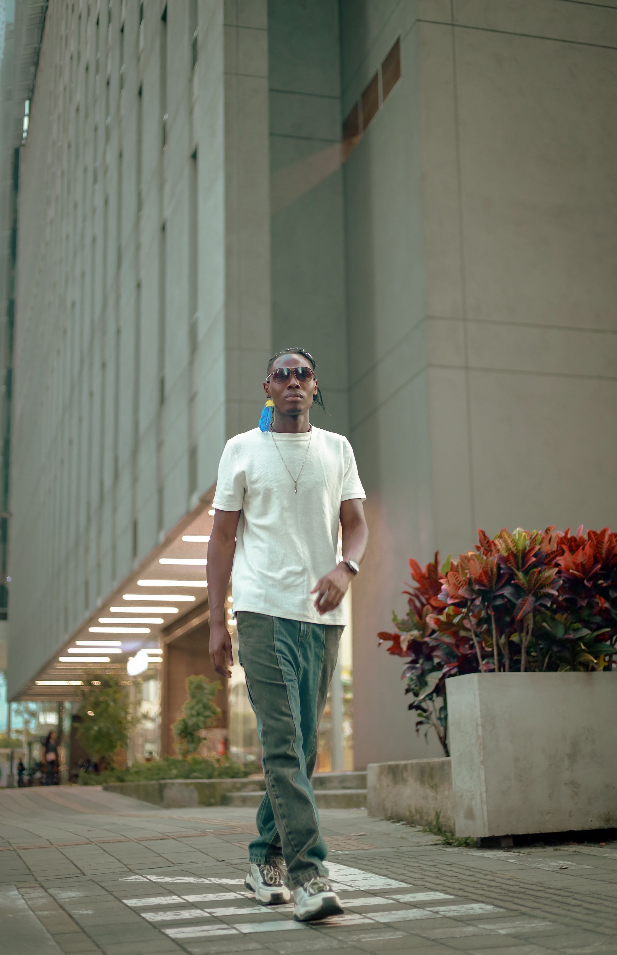 Man in a casual outfit walking on a city sidewalk in mild weather