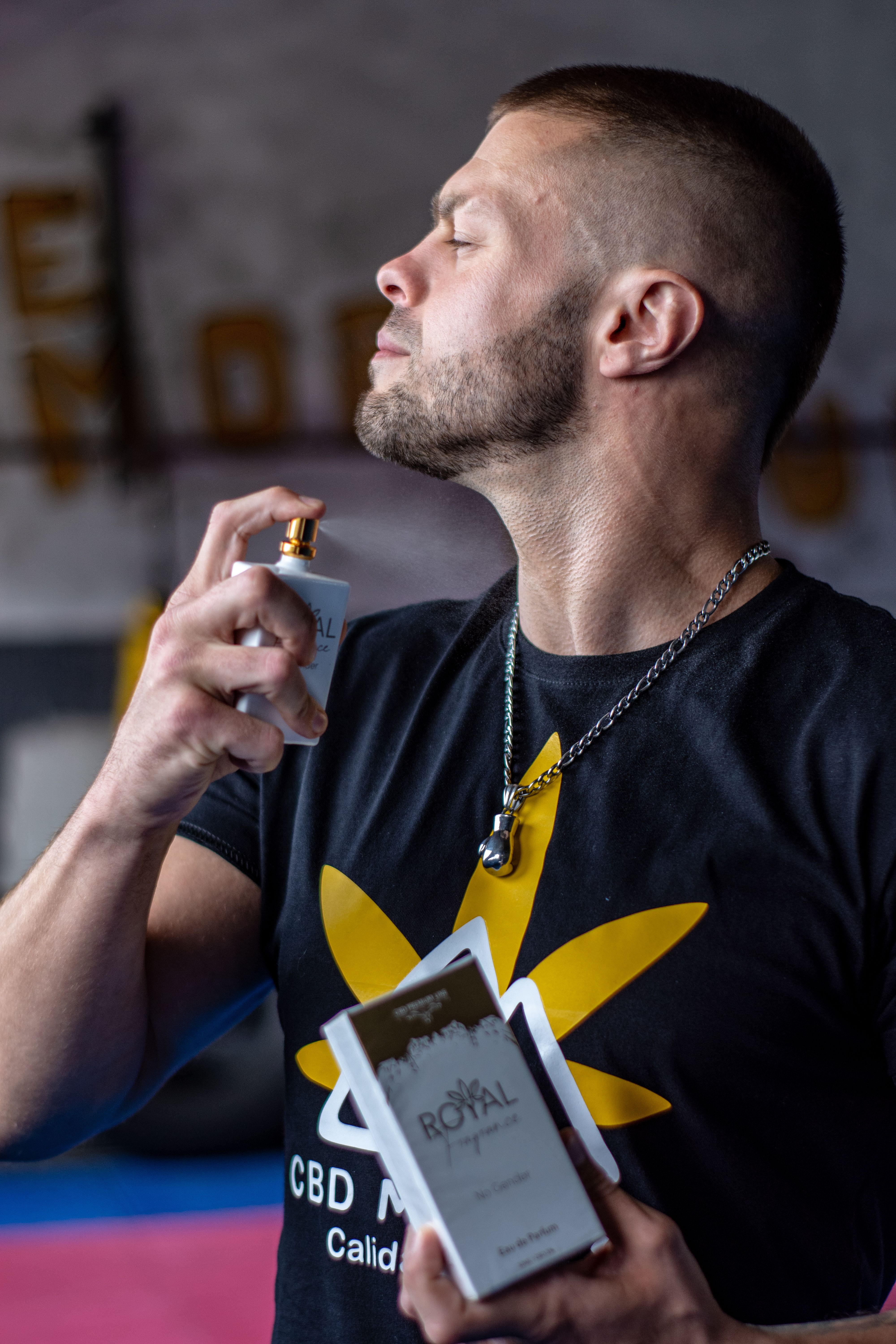 Man in Tshirt Using Perfume · Free Stock Photo