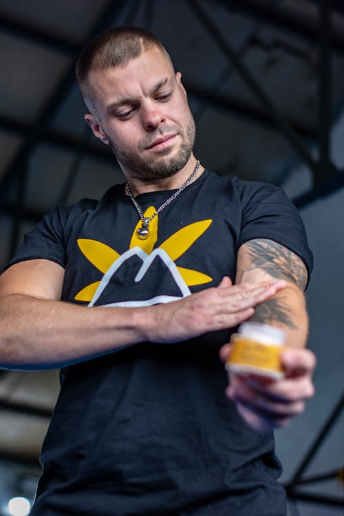 Man with Tattoos Using Cream