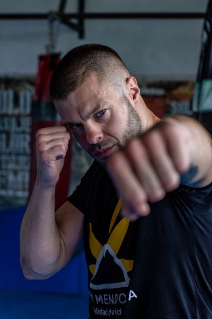 Fotomural Retrato de un boxeador masculino en un gimnasio, de pie con los puños listos para la acción.