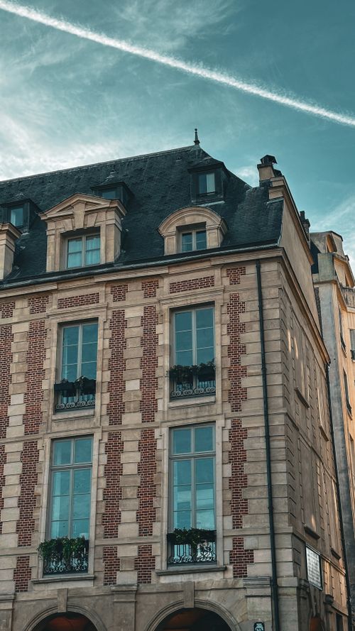 Free Charming facade of historic building at Place des Vosges, Paris, showcasing classic French architecture. Stock Photo