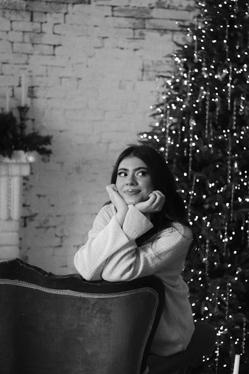 Smiling Woman Looking Expectantly Standing by the Christmas Tree