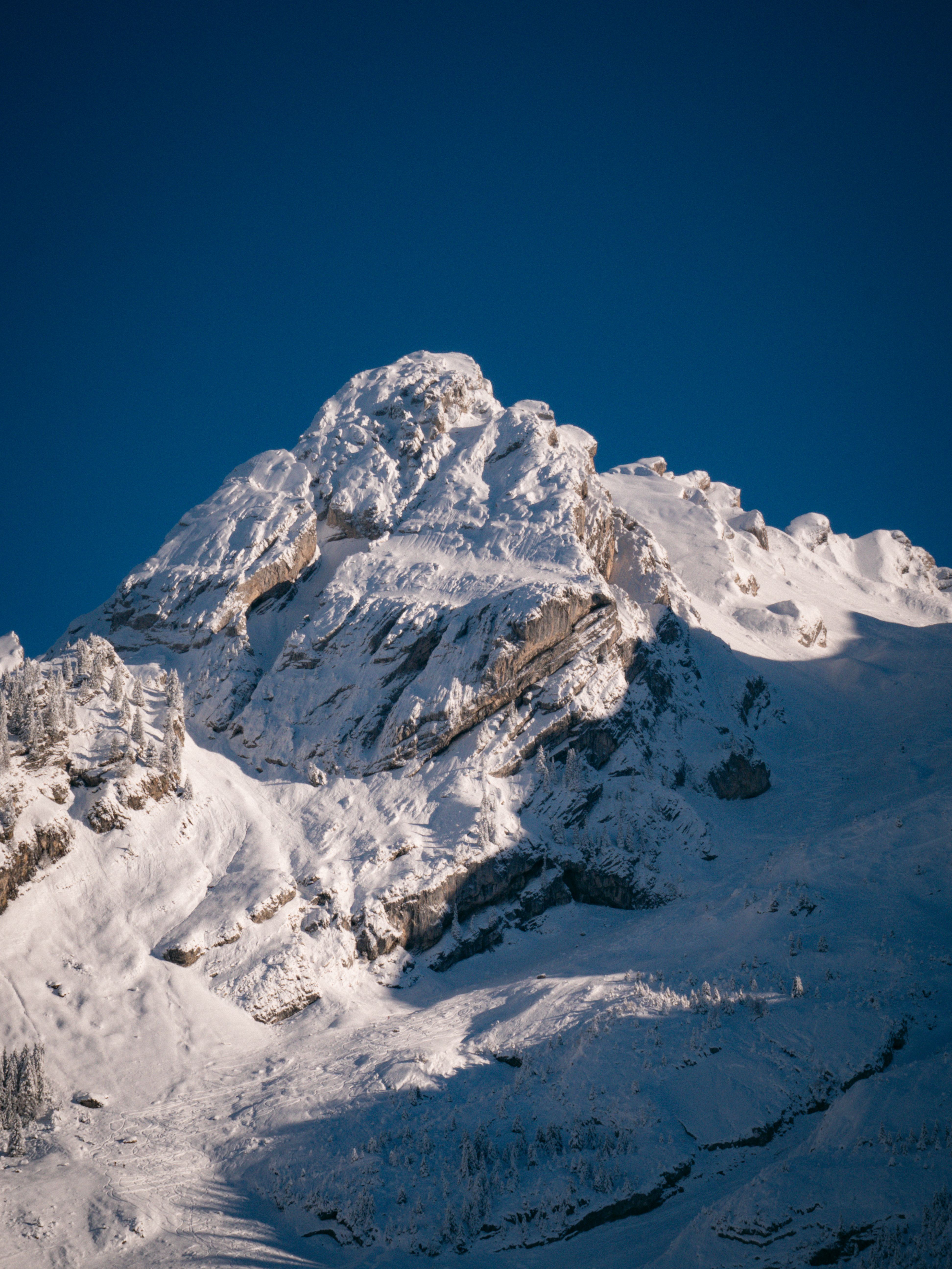 A snow covered mountain with a blue sky · Free Stock Photo