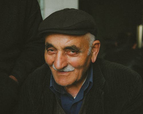 Elderly Man with a Gray Mustache in a Flat Cap