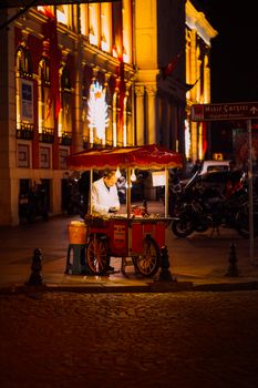 Street food vendor in Istanbul under warm lights at night, showcasing vibrant urban culture.