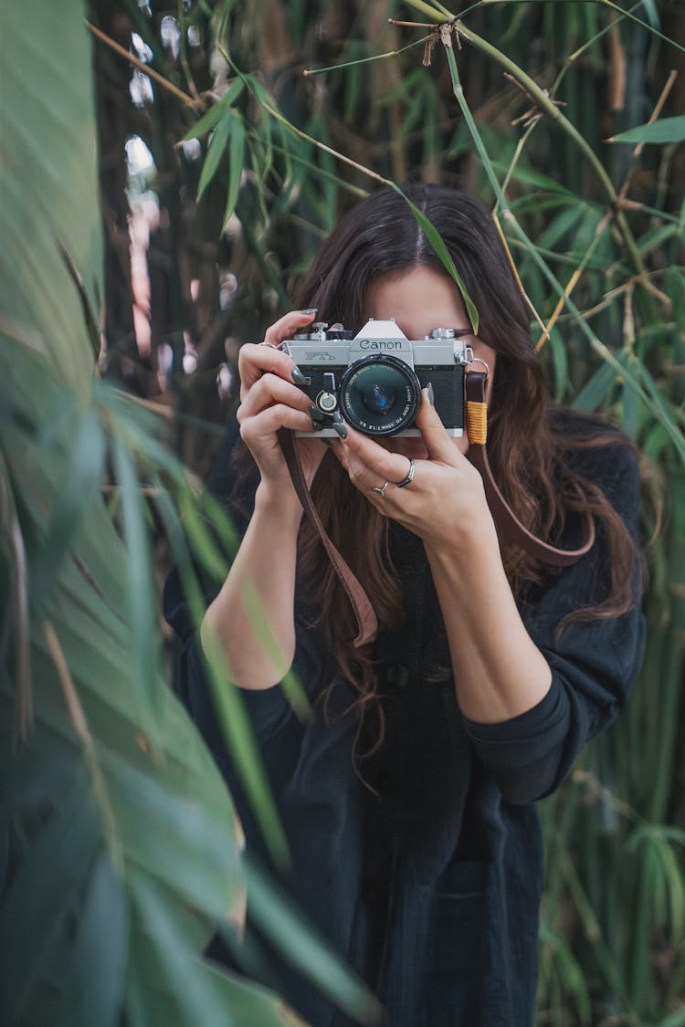 A Woman Taking Pictures With A Camera Outside 