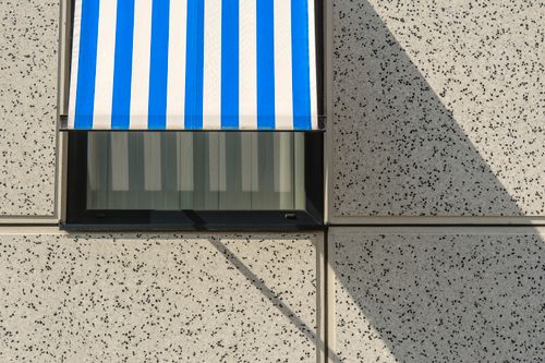 Free Abstract view of blue and white awning casting shadows on a speckled wall. Stock Photo