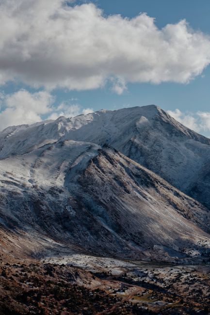 Breathtaking view of snowy Rocky Mountain peaks with clouds overhead.