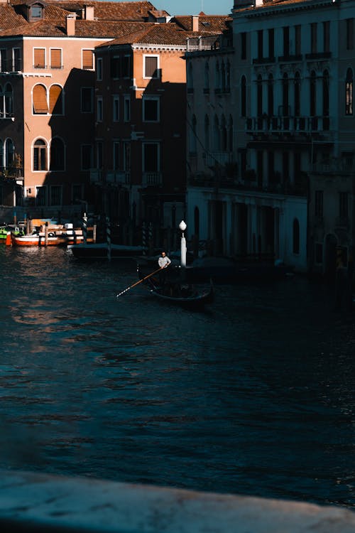 Man on a Boat in a Water Canal, Venice, Italy 