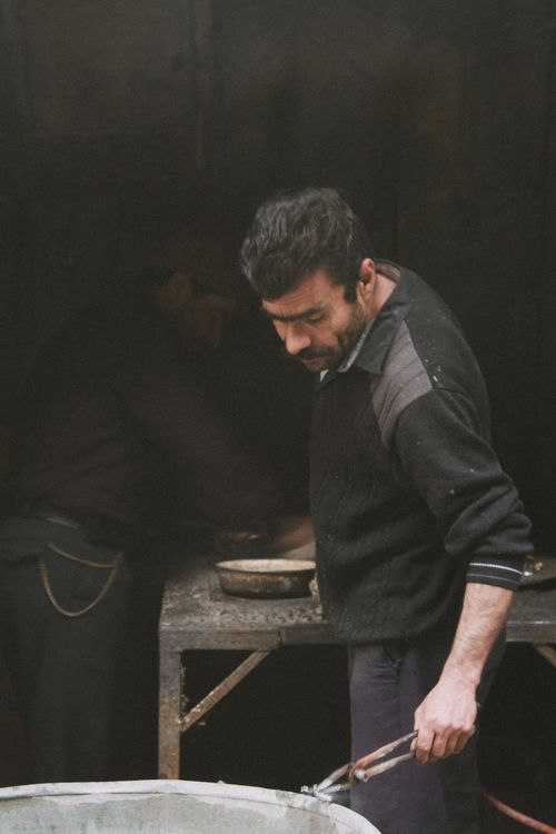 Free Portrait of artisan blacksmith at work in a dimly lit workshop, focusing on his craft. Stock Photo