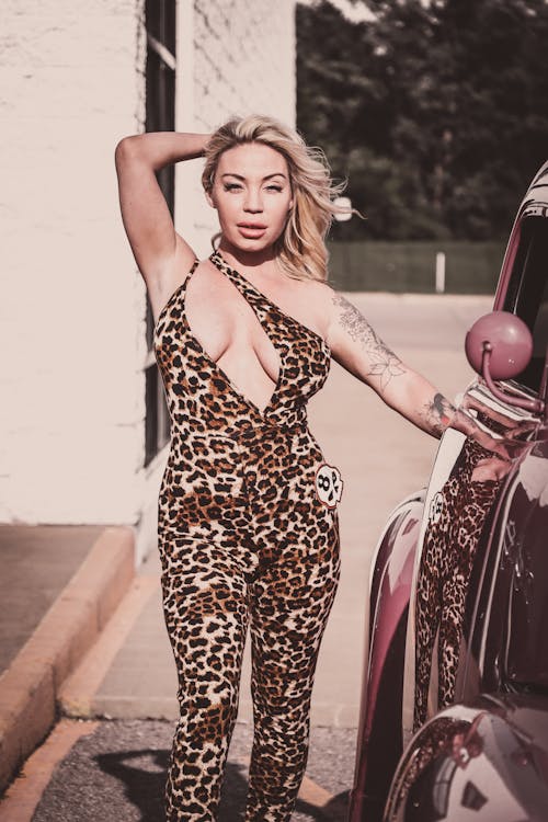 Woman Wearing a Cheetah Print Outfit Standing next to a Car 