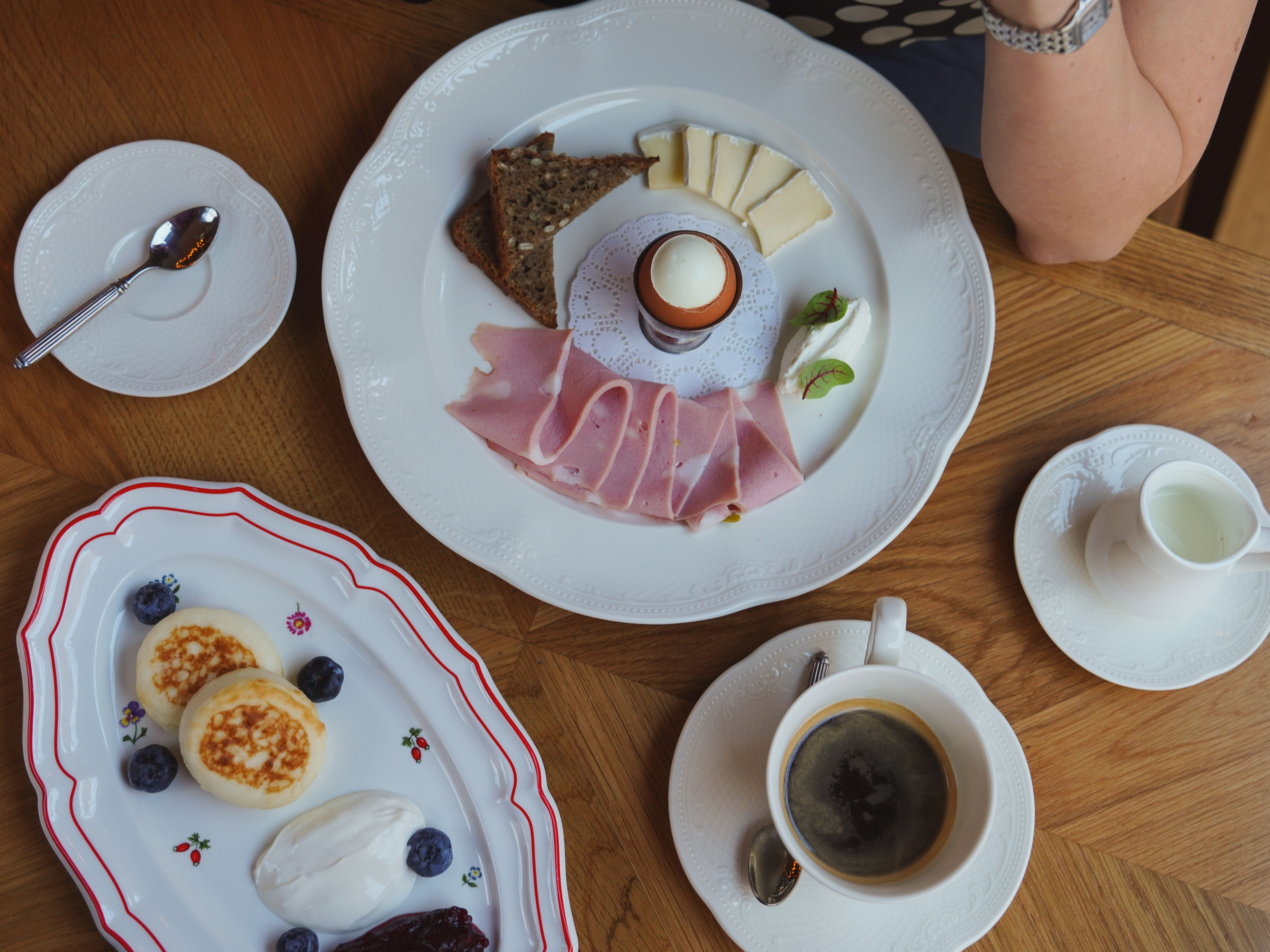 A top-down view of a delicious breakfast spread featuring ham, cheese, eggs, and coffee.