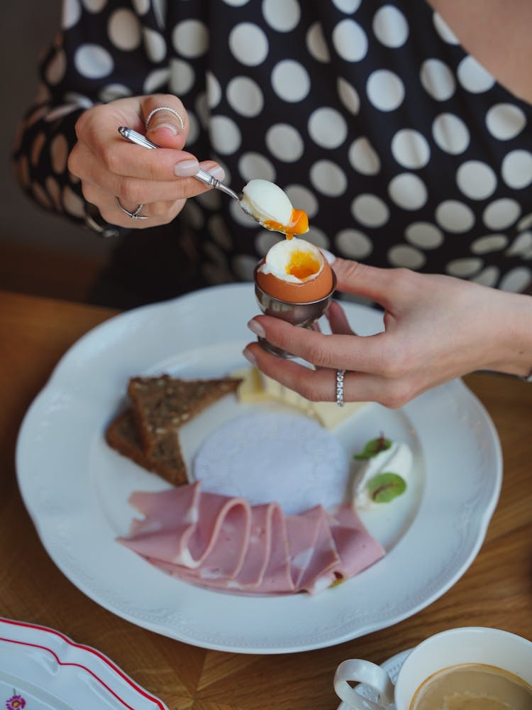 A Woman Eating An Egg