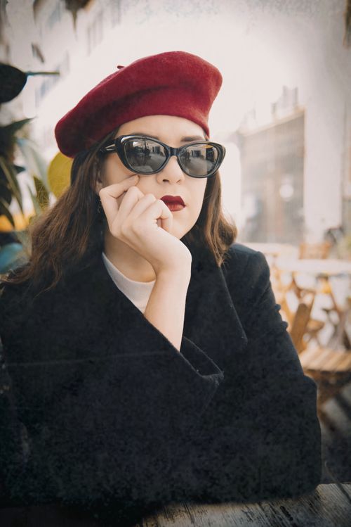 Free Stylish woman in a red beret and sunglasses at a cafe. Fashionable and elegant. Stock Photo