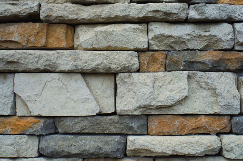 Close-up of a textured stone wall with a variety of natural colors.