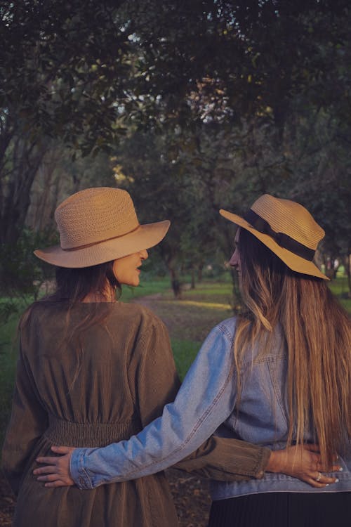 Women Wearing Straw Hats in a Park