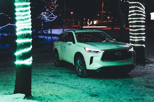 White 22 Infiniti QX60 Parked Between Illuminated Trees 