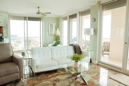 White Sofas in the Middle of the Living Room of a Corner Apartment Overlooking the Sea