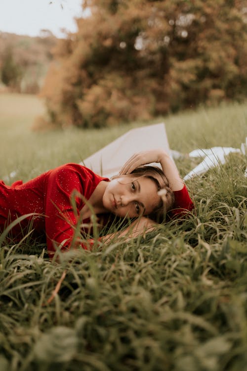 Free Portrait of a Young Woman Relaxing on the Grass Stock Photo