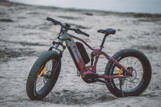 Electric bicycle with fat tires parked on a sandy beach, symbolizing modern outdoor transportation.