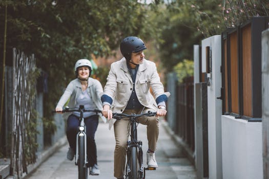 A happy couple enjoys a ride on electric bicycles through a scenic urban alley.