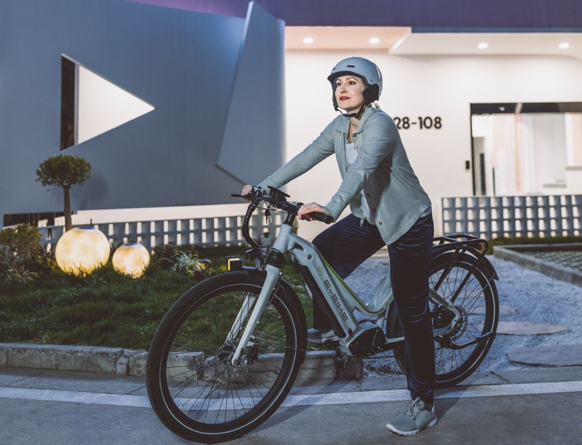 Ciclista com bicicleta elétrica em cenário urbano