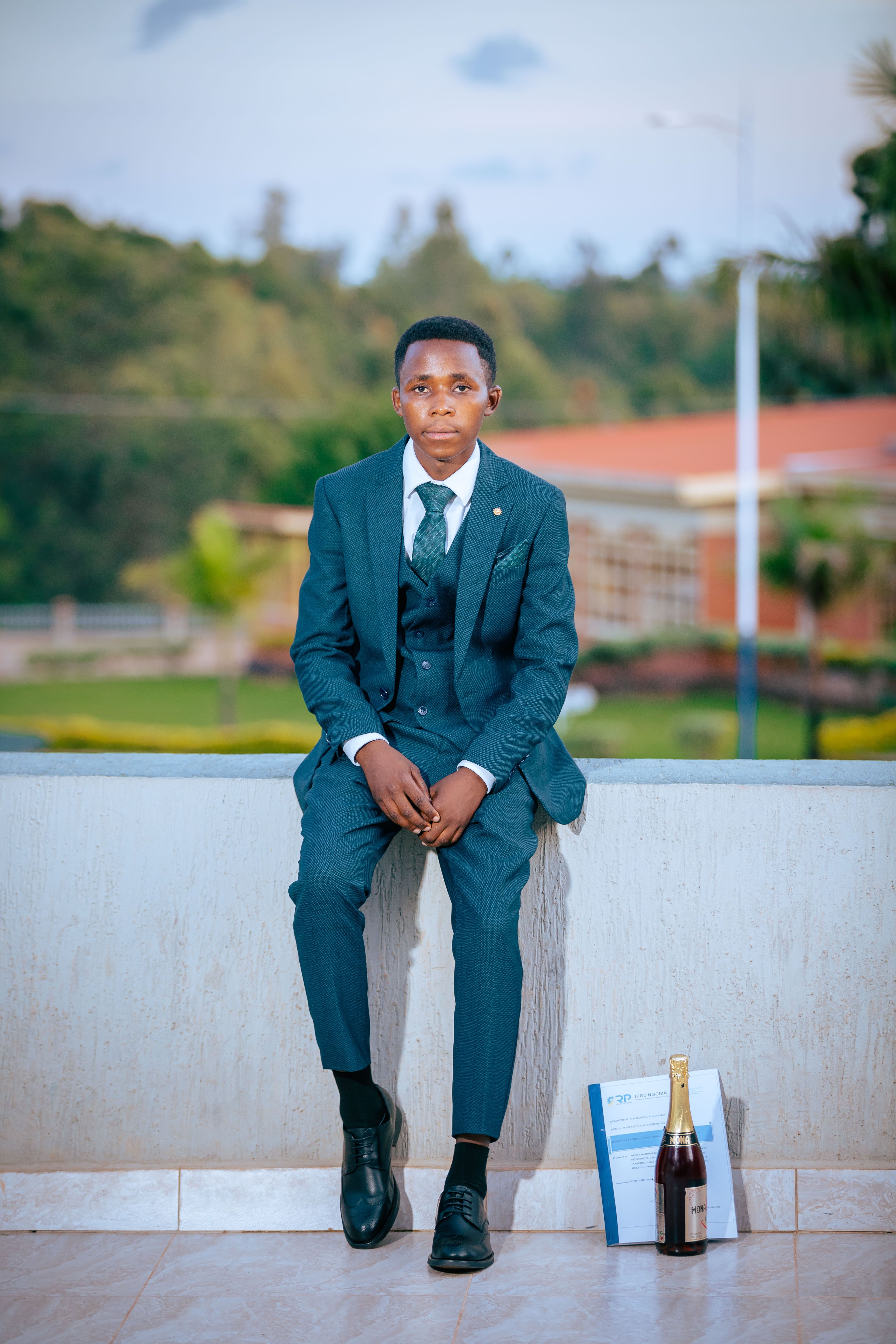 Young man in suit posing outdoors with a bottle of champagne, exuding elegance.