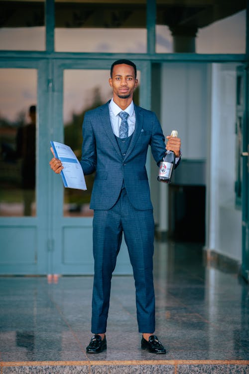 Man in Suit Standing with Champagne Bottle