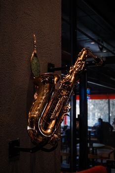 A sleek saxophone mounted on the wall inside a cozy Konya cafe, adding musical charm.