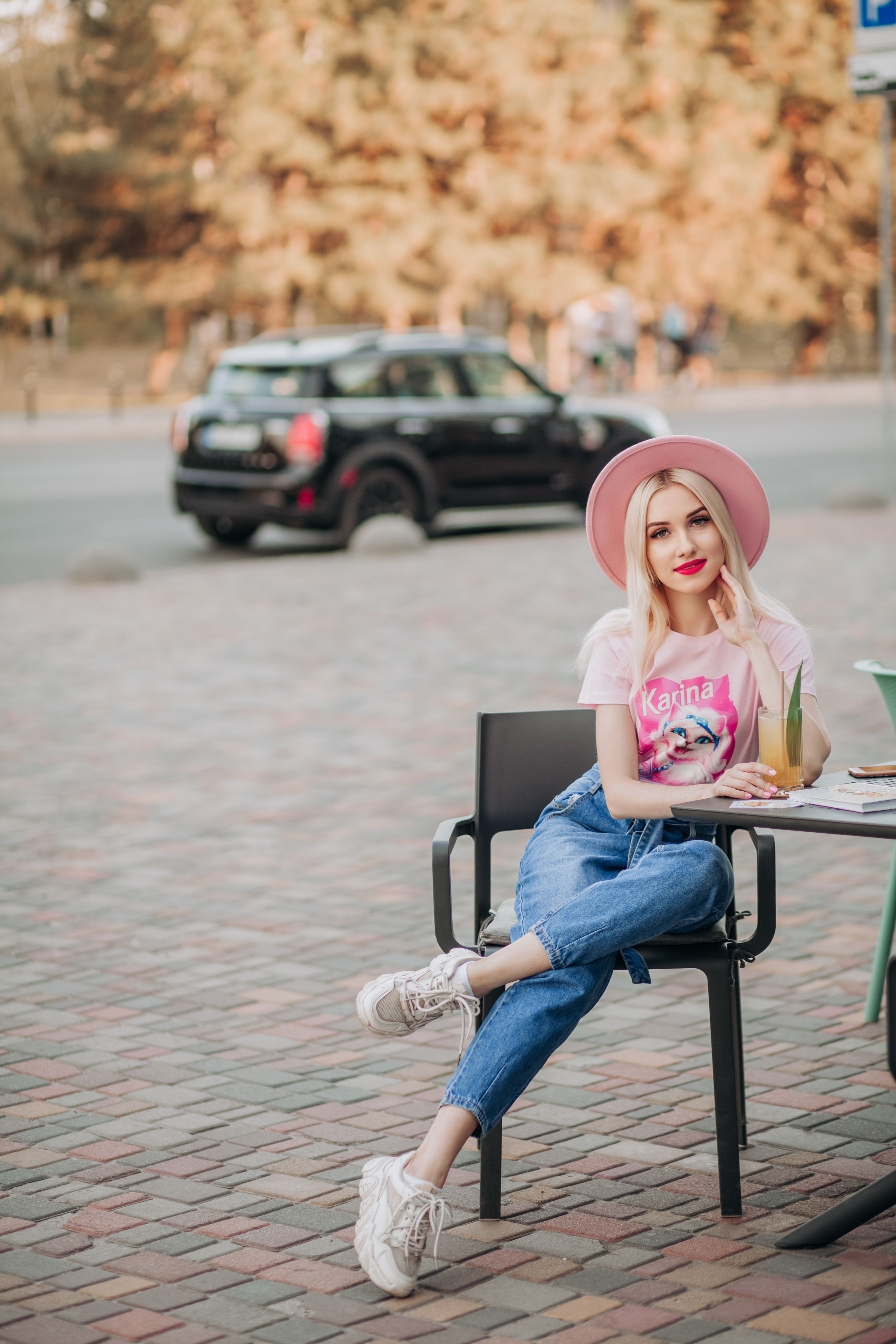 Chic young woman enjoying leisure time outdoors at a cafe in summer.