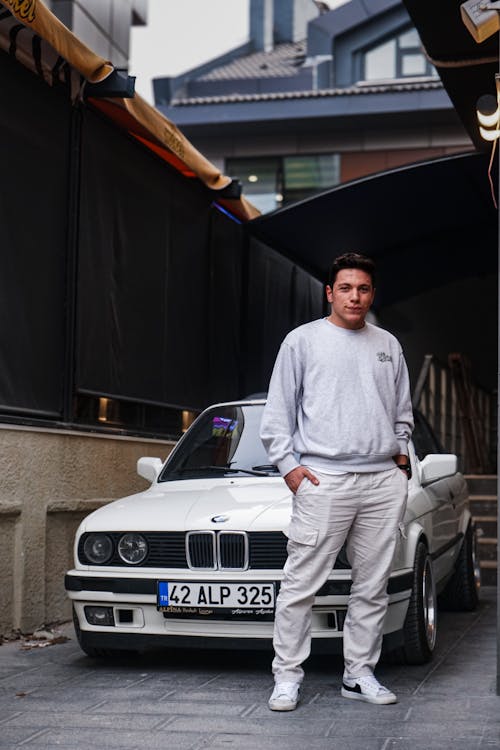 Portrait of a Man Standing in Front of a White Vintage BMW