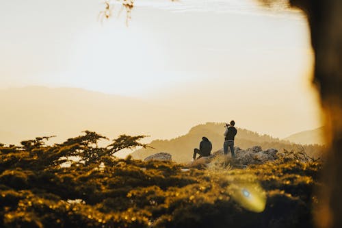 Men on Top of the Mountain Filming a Golden Sunset