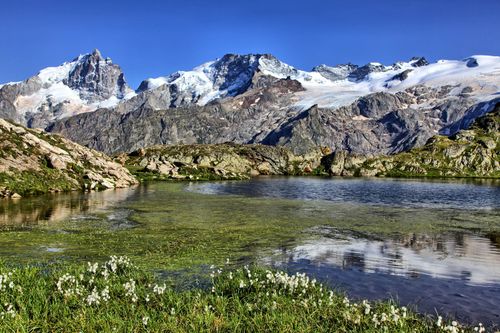 Free Stunning view of a lake in La Grave, France with alpine mountains and clear blue sky. Stock Photo