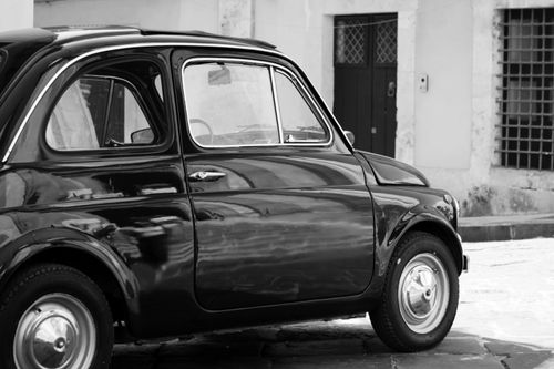 Free Classic vintage car captured in a vintage black and white street setting, exuding retro charm and timeless elegance. Stock Photo