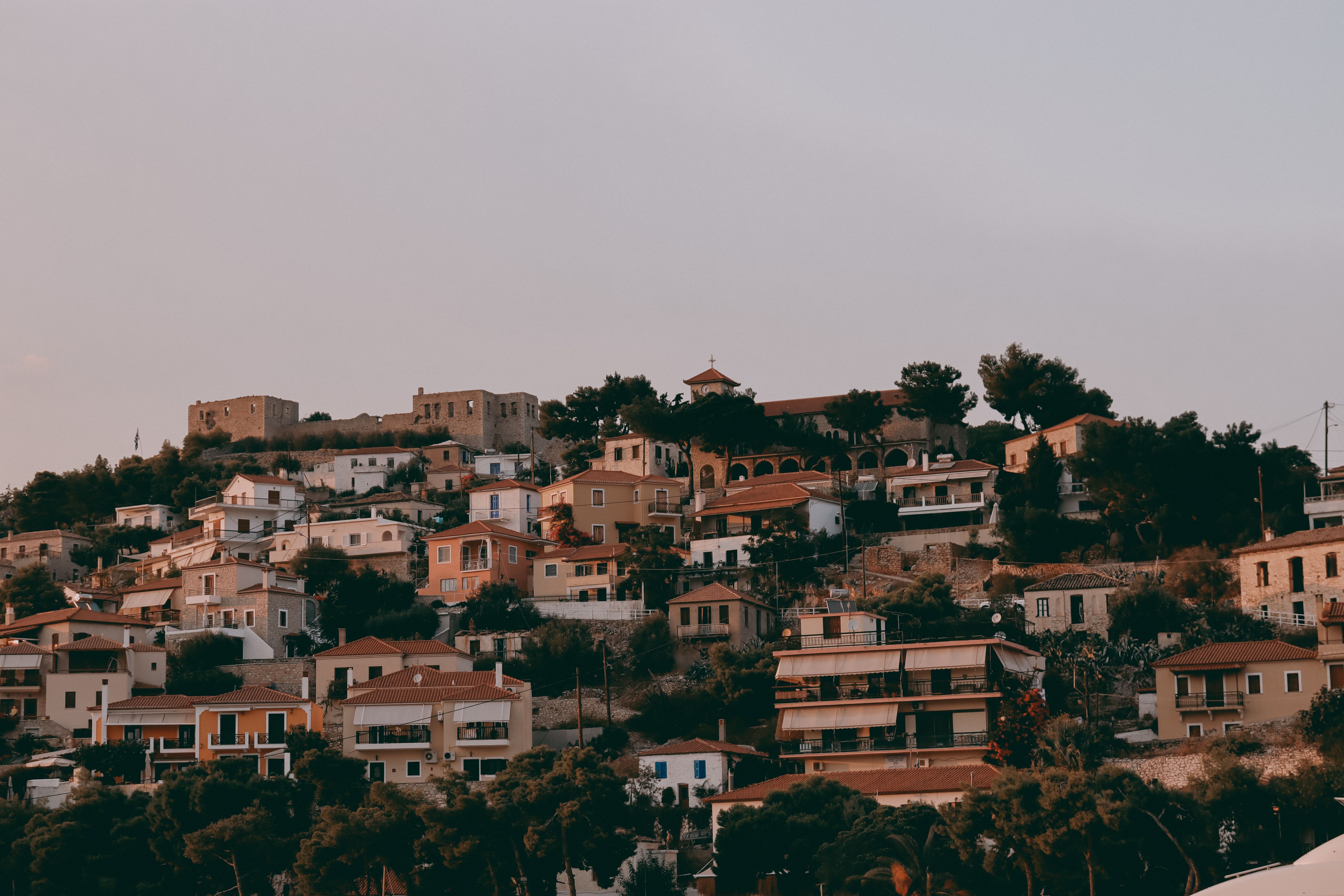Scenic view of Paralio Astros village, Greece, with its charming houses under a warm sunset sky.