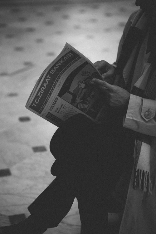 Free Monochrome image of a person reading a newspaper indoors in Ankara, capturing a moment of leisure. Stock Photo