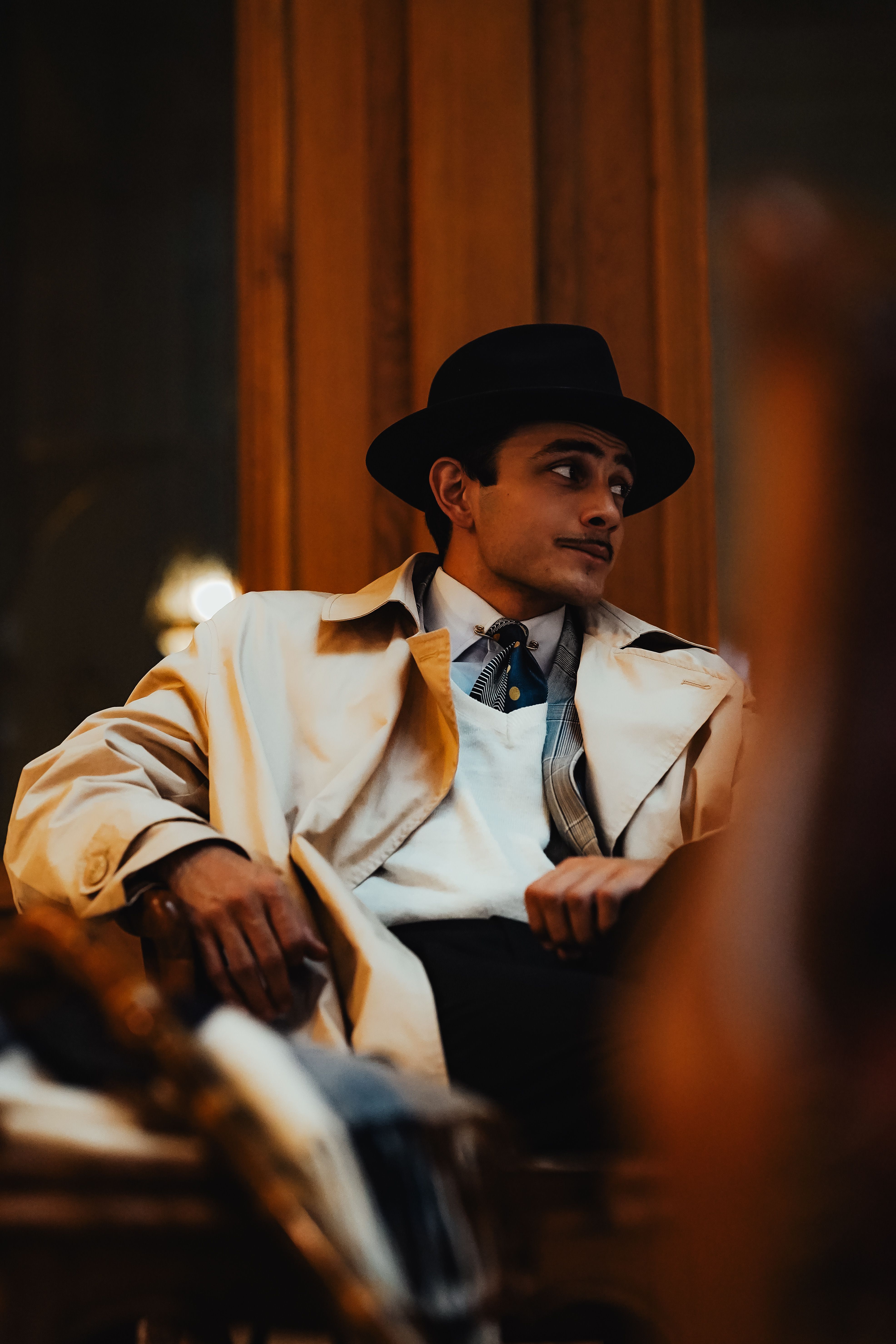 Man in hat and coat sitting outdoors