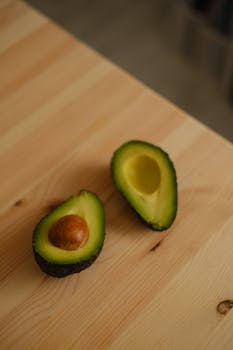 A close-up of a cut avocado showcasing its freshness on a wooden table.
