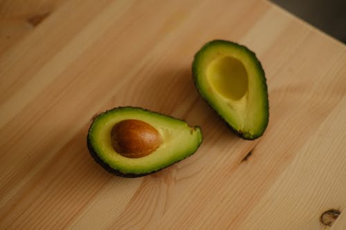 Photo of a Halved Avocado on a Wooden Table