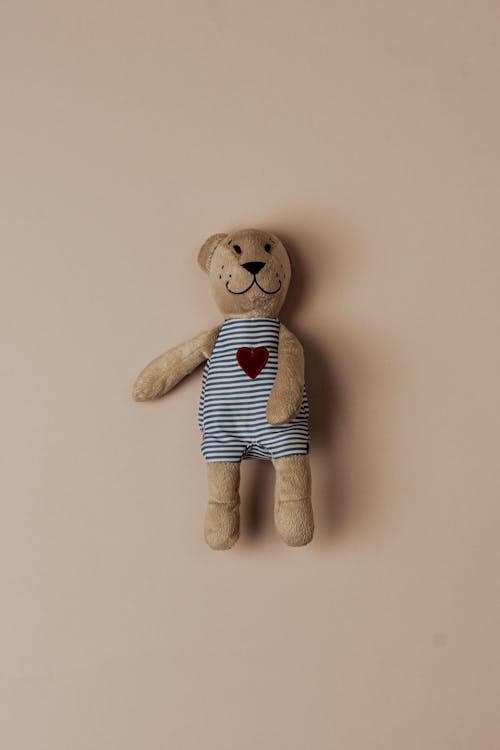A Teddy Bear Lying on Beige Background 