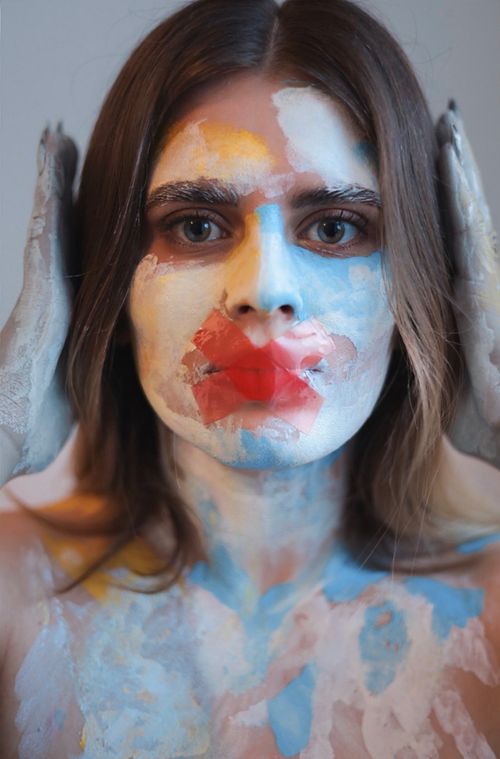 Free Portrait of a woman with vibrant face paint expressing creativity and emotion. Stock Photo