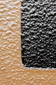 Close-up of a snow-covered urban texture with contrasting colors and geometric patterns.