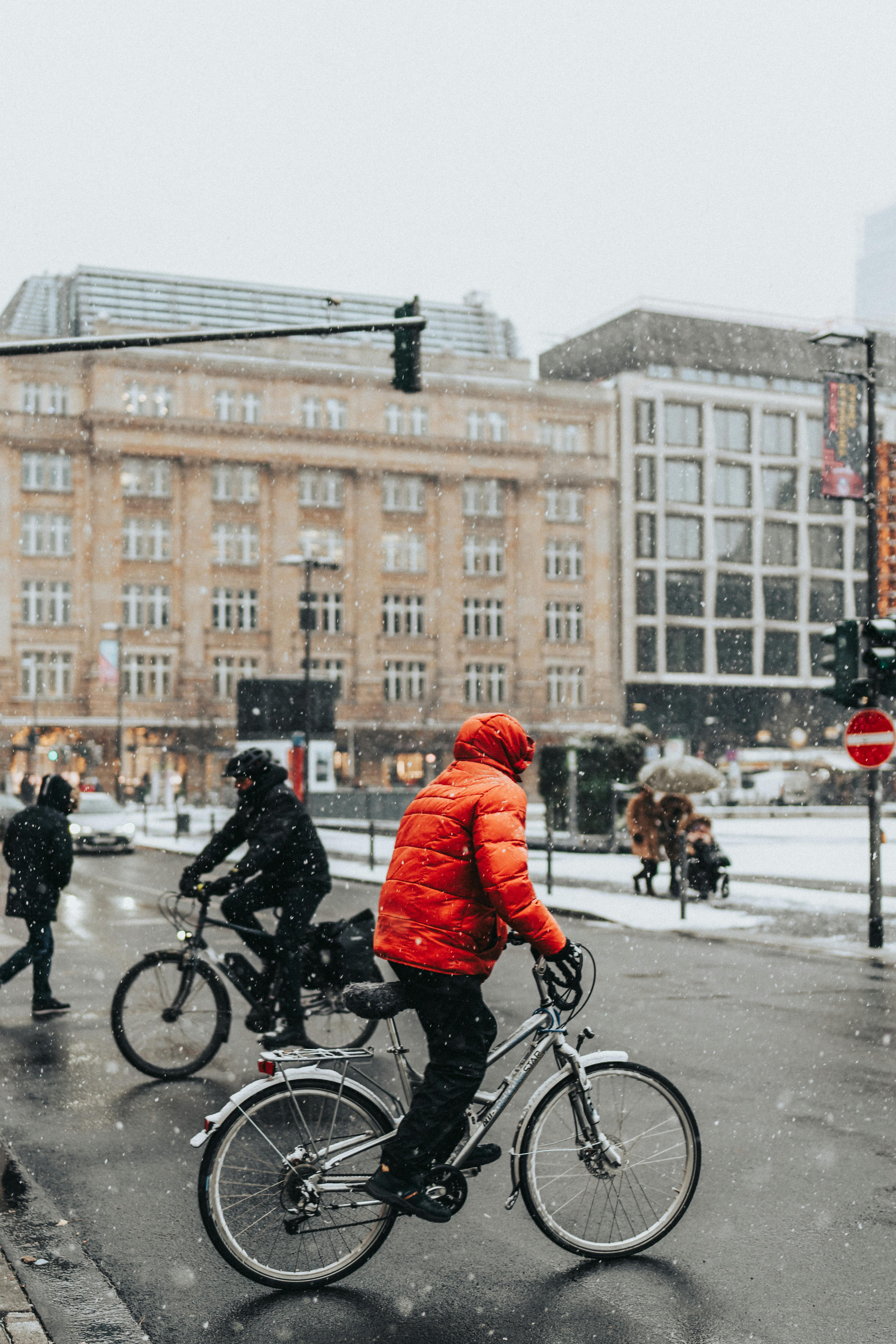 People Riding Bikes on Street in City in Winter Free Stock Photo
