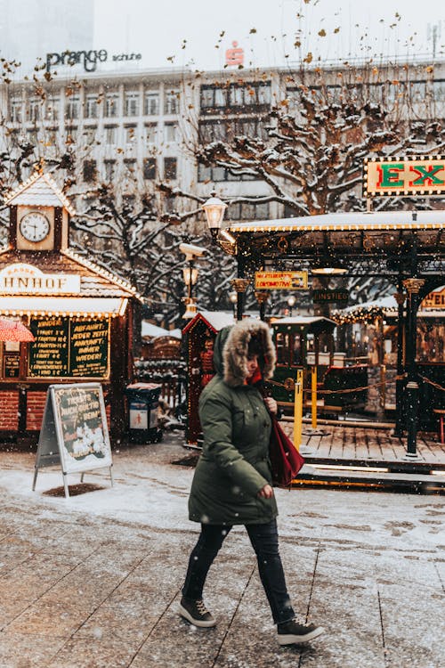 Woman Walking Among Booths on a Christmas Market 