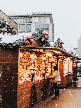 Festive winter scene at a bustling Christmas market with people shopping in snowy weather.