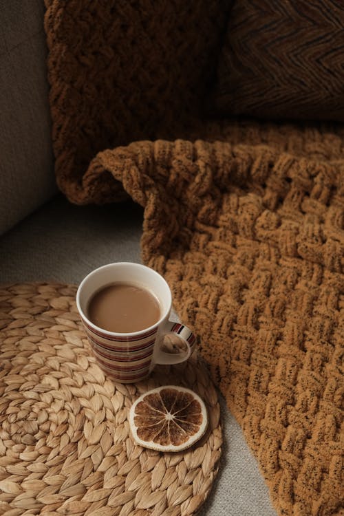 Free Coffee Served in a Cup Next to a Blanket  Stock Photo