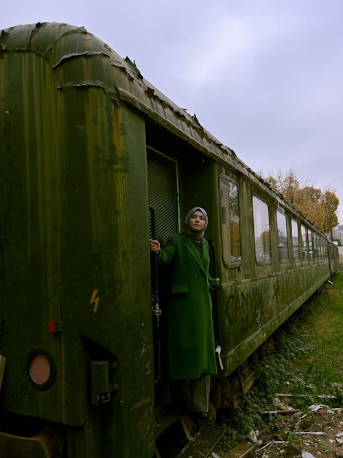 Woman Wearing Green Coat in Front of Carriage 